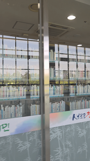Bookshelves seen through the glass wall of a Korean public library