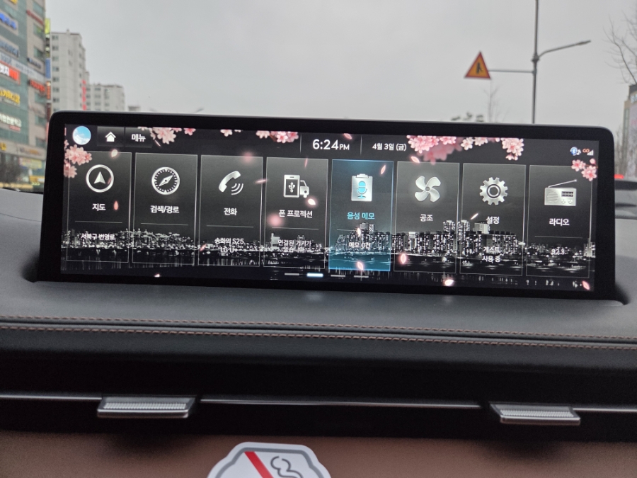 A Korean car navigation screen with a cherry blossom spring theme